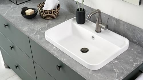 Rounded washbasin and bathroom counter top with stone appearance