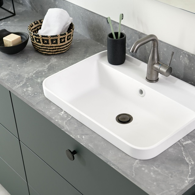 Rounded washbasin and bathroom counter top with stone appearance