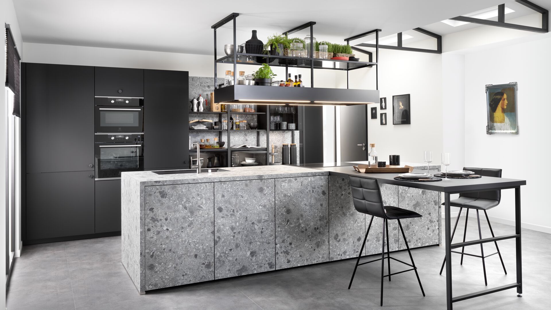 Kitchen with terrazzo-style island and black units with suspended shelves