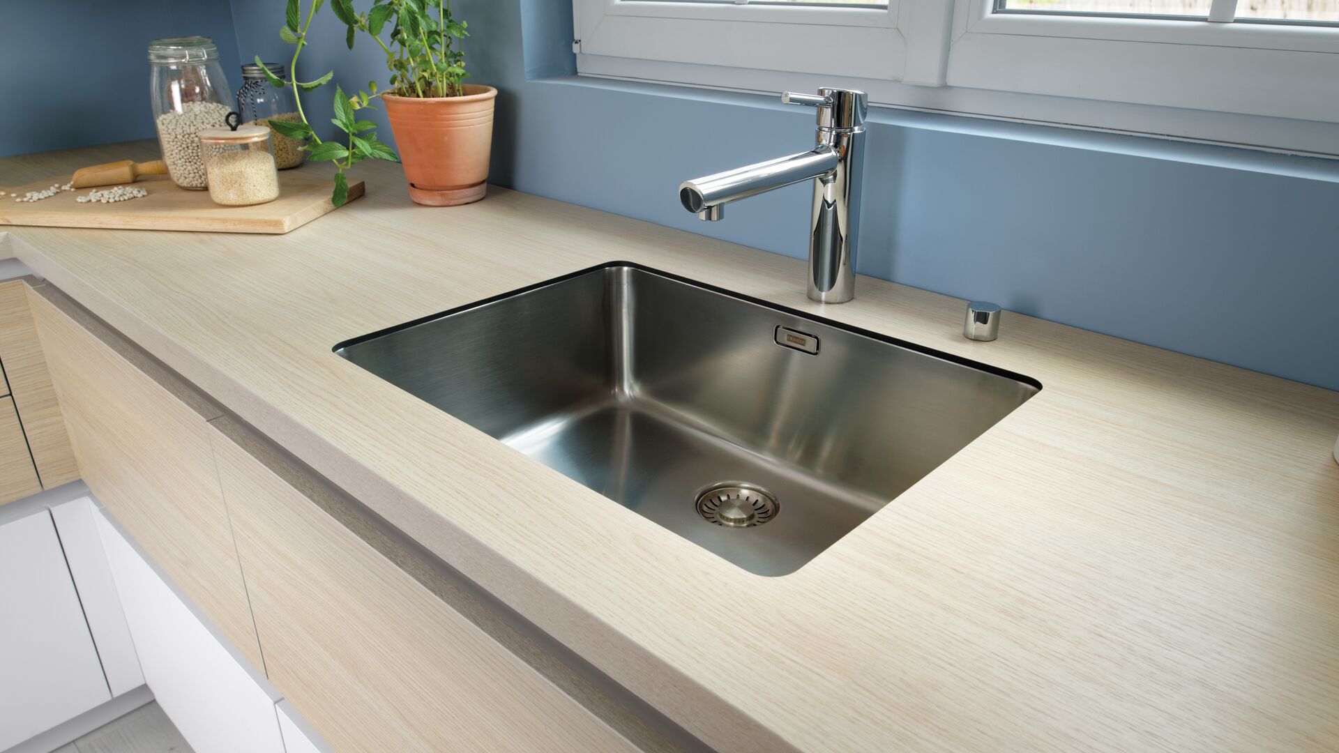 évier moderne avec cuve sous plan de travail et mitigeur en inox, plan de travail bois clair