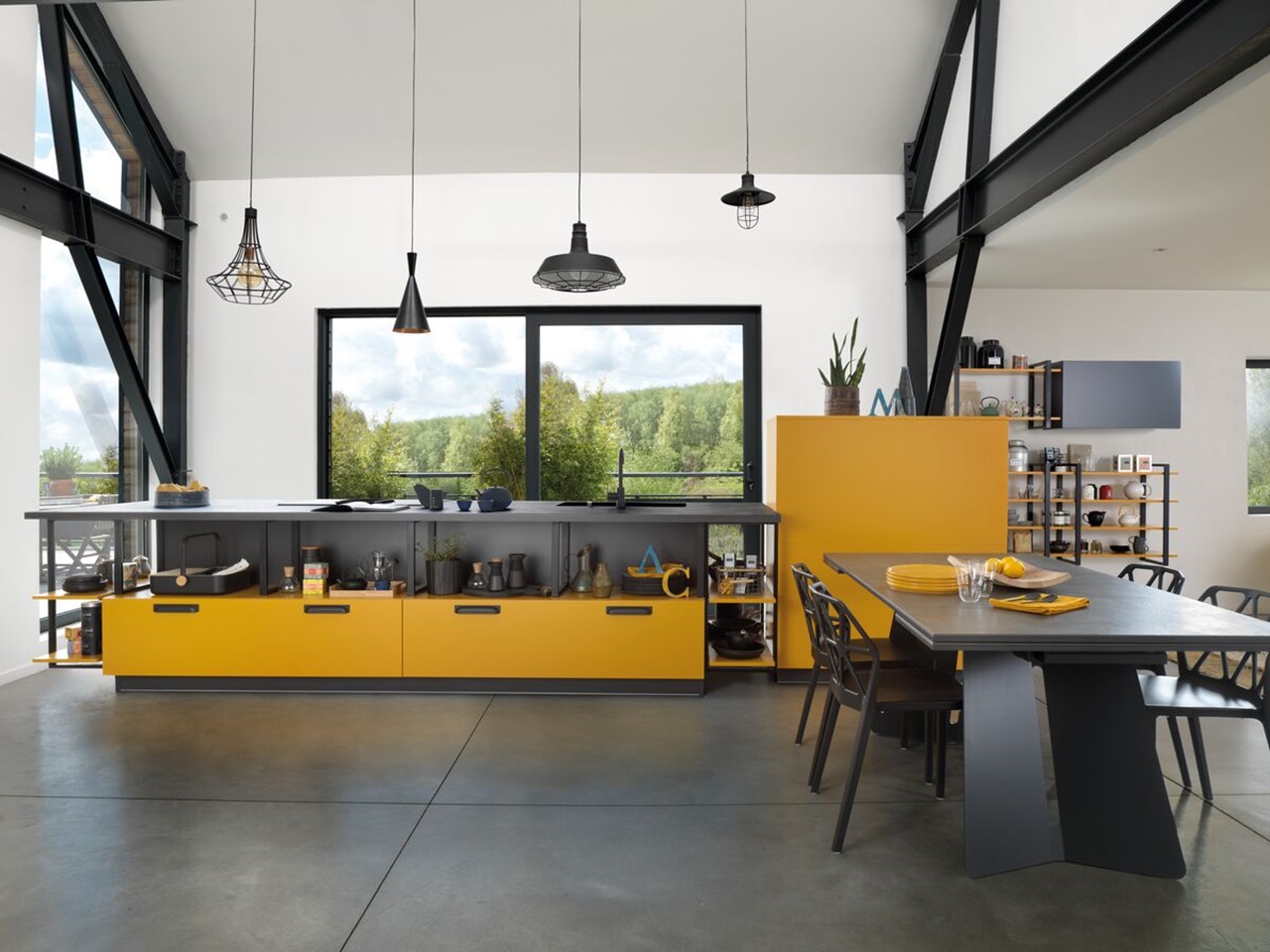 gelbe Design-Küche offen zum Essbereich mit Design-Stühlen und schwarzem Tisch