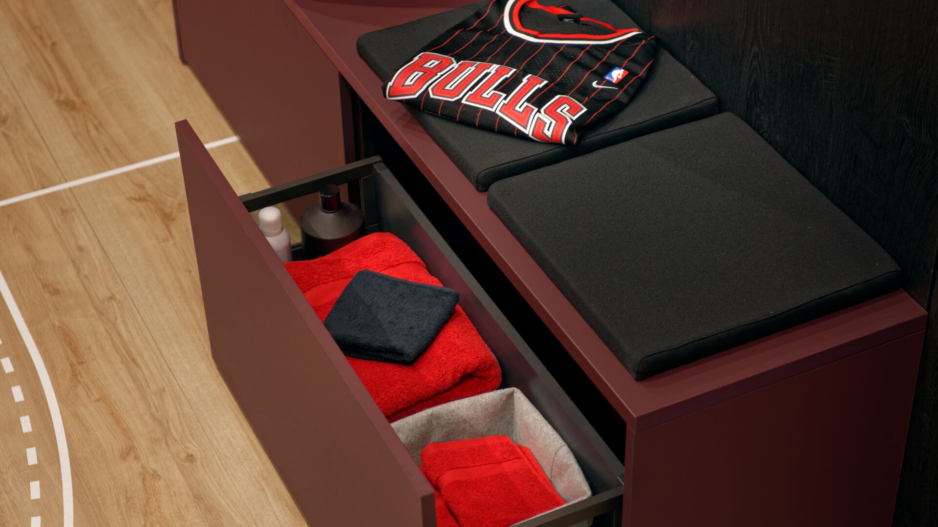 Bench with open pull-out storage cubby for sports equipment
