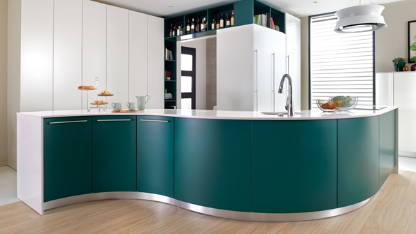 S-shaped rounded island in a green and white kitchen
