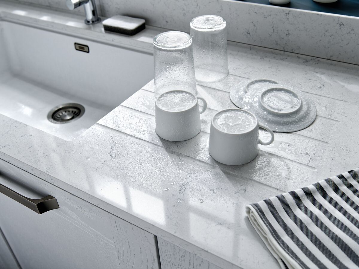 Superficie de trabajo ranurada con escurridor de platos equipado con fregadero y recipiente debajo de la encimera