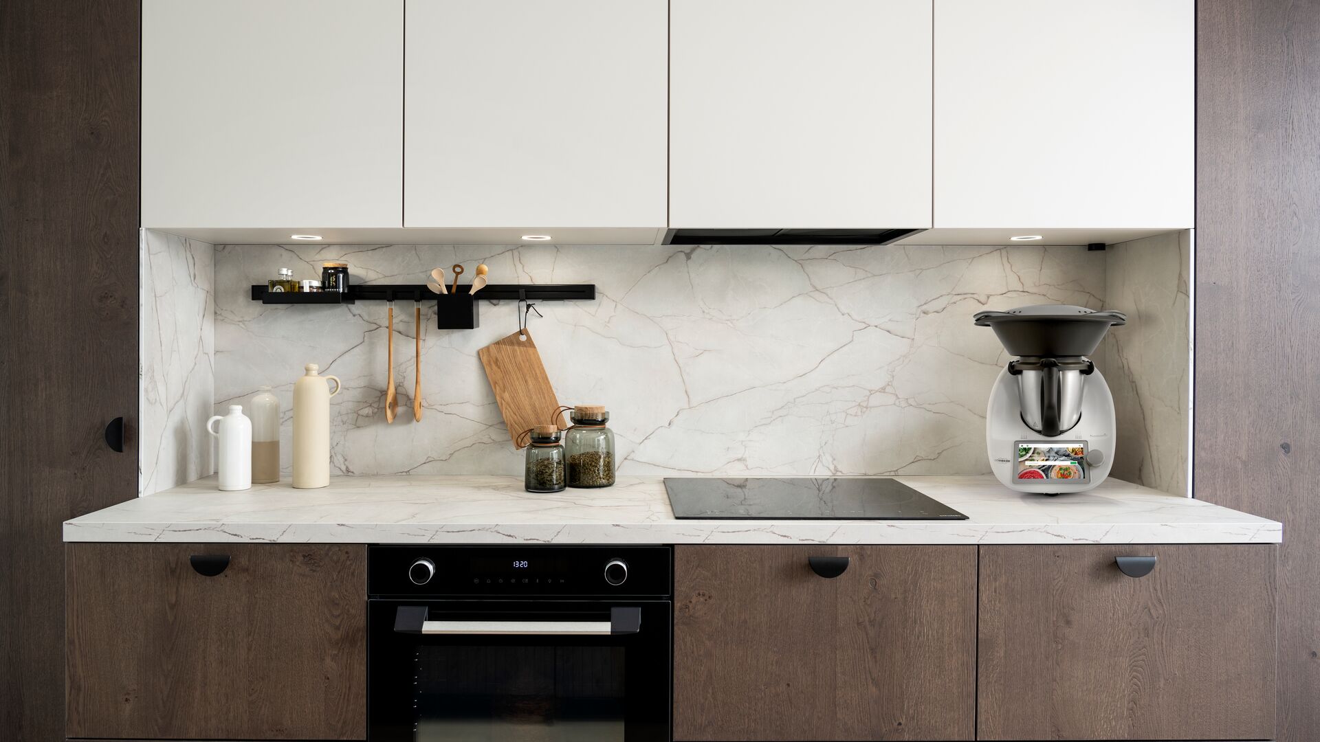 Gekleurde keukenachterwand over de hele lengte met een wit gelakt keukenmeubel