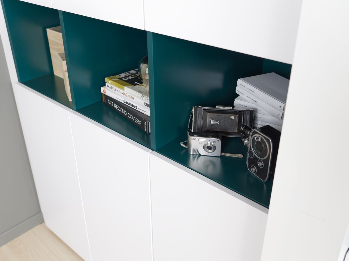 Vue zoomée sur le rangement intermédiaire vert du dressing blanc