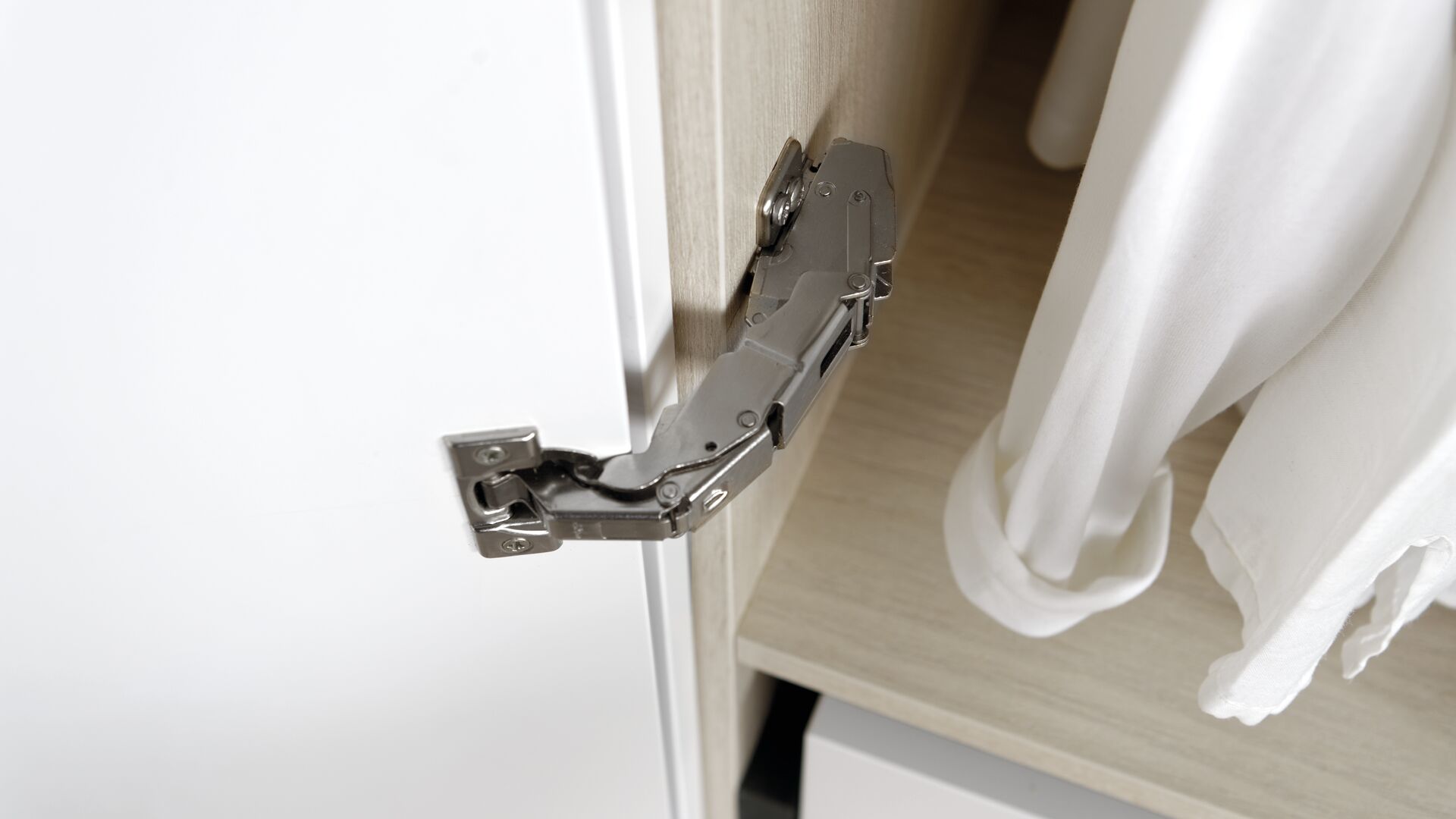Detailansicht auf das mittige Türscharnier der weißen Ankleide