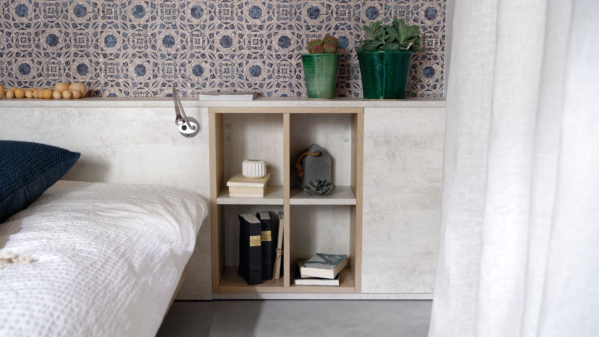 Atmosphärische Ansicht des Schranksystems in Arcos Melamindekor in hellbeige, gerahmt auf der Nische des Kopfteils des Bettes